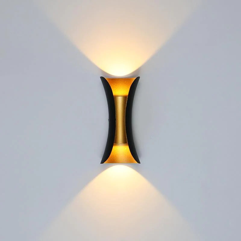 Een stijlvolle LUMIO LED wandlamp verlicht een moderne tuin 's avonds. Een close-up van de LUMIO LED wandlamp, bevestigd aan een buitenmuur, toont het strakke en moderne design. Een gezellige woonkamer met de LUMIO LED wandlamp die zacht warm wit licht uitstraalt.