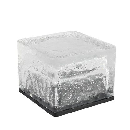 Moderne vierkante solar buitenlamp verlicht een tuinpad.